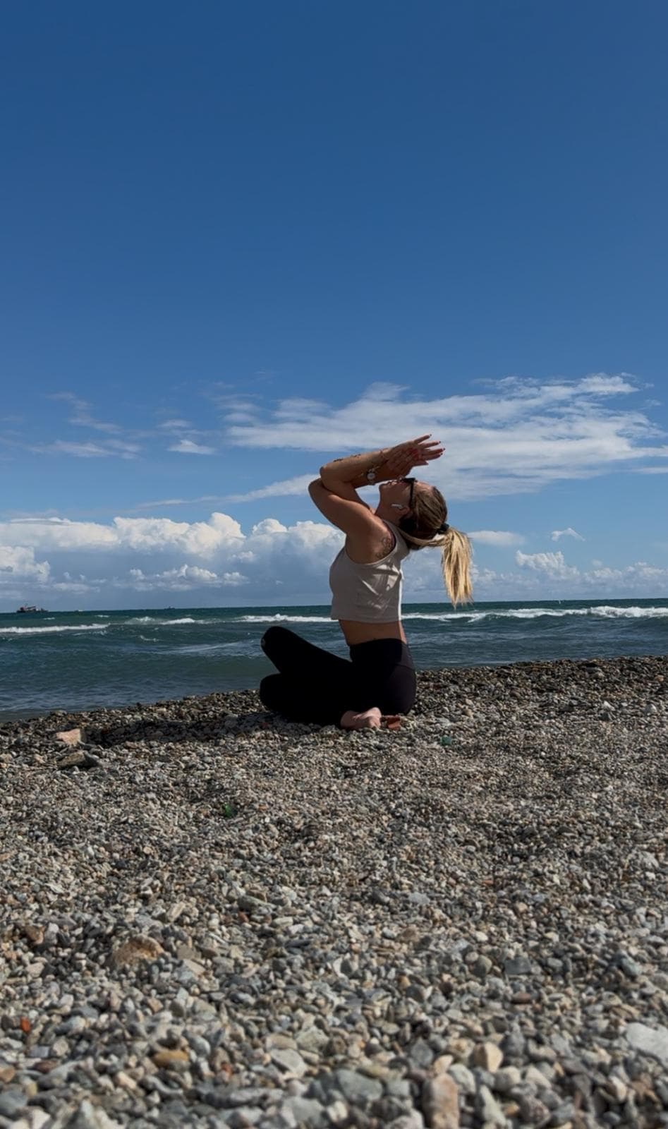 Silvia pratica yoga sulla spiaggia con vista mare