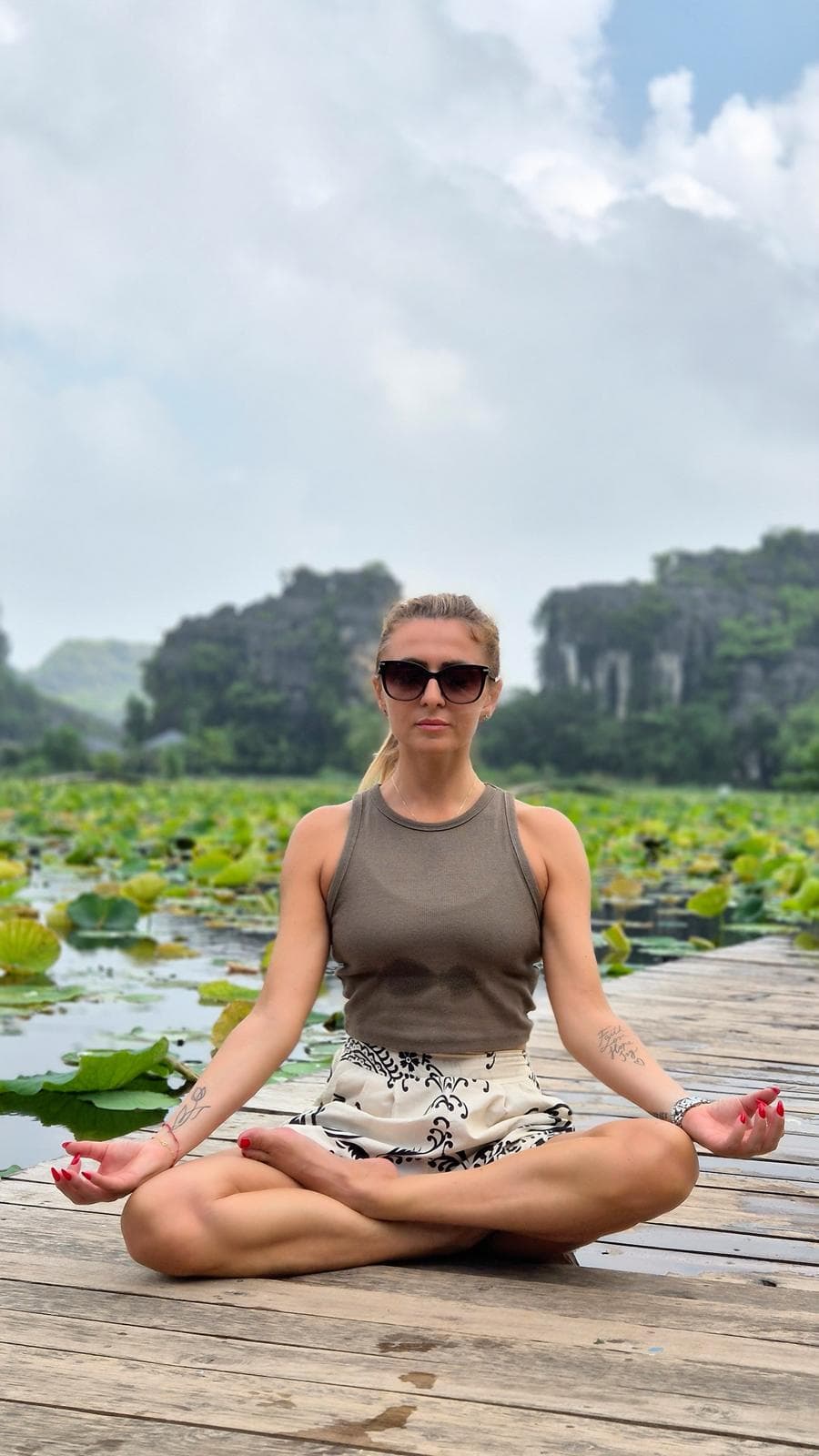 Silvia in meditazione su un pontile con fiori di loto